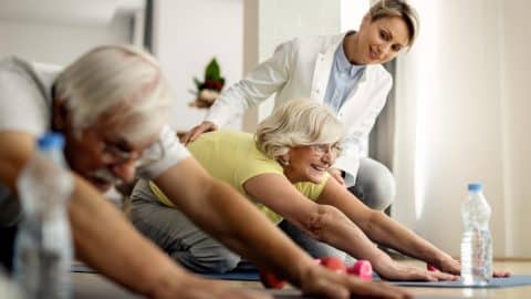 happy mature couple doing stretching exercises with help physiotherapist home happy mature couple doing stretching exercises with help physiotherapist home